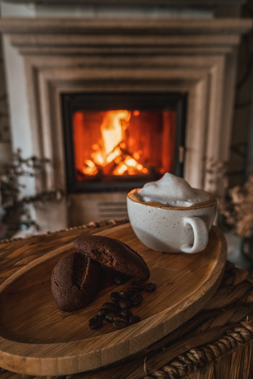 cup of cappuccino and madeleine chocolate cakes on wooden plate
