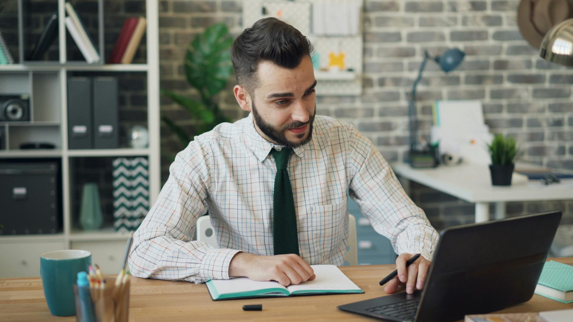 young man using a laptop in a modern office
